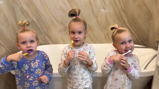 Little Sisters Triplets Twins Brushing Teeth Bathroom Front Mirror Dressed — Stock Video