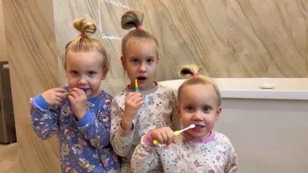 Little Sisters Triplets Twins Brushing Teeth Bathroom Front Mirror Dressed — Stock Video