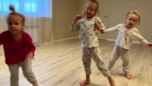 トリプル姉妹の子供たちは部屋で自宅で踊り パジャマは底に身を包み 足の底は裸で長いブロンドの髪です 高品質の4K映像 — ストック動画