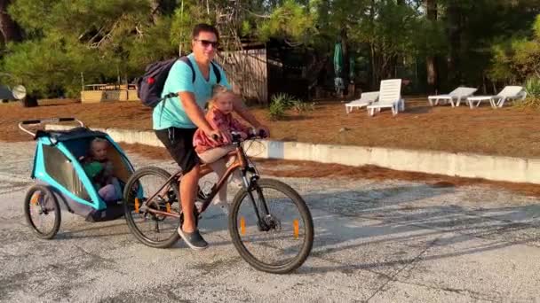 Papá Monta Una Bicicleta Con Remolque Bicicleta Para Niños Pegado — Vídeos de Stock