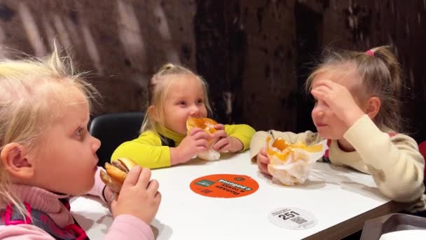 Dvojčata Triplet Sestry Jíst Hamburgery Rukama Sedí Fast Food Restauraci — Stock video