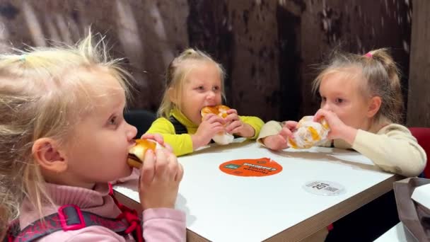 Hermanas Gemelas Trillizas Comiendo Hamburguesas Con Las Manos Sentadas Restaurante — Vídeo de stock