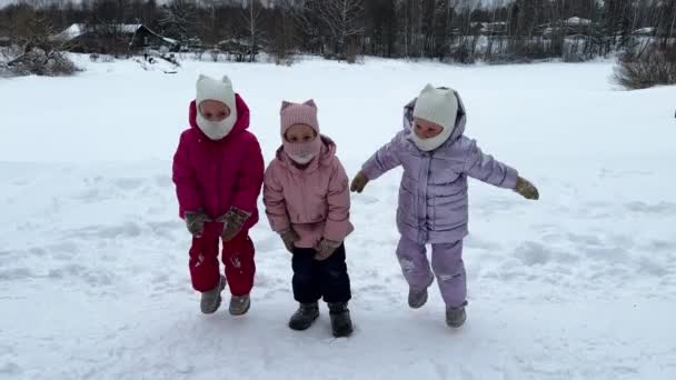 Παιδιά Των Τριδύμων Μικρών Αδελφών Χειμώνα Πηδούν Στο Χιόνι Φορούν — Αρχείο Βίντεο
