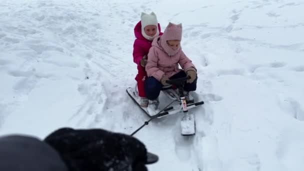 Tata Niesie Dwie Bliźniaczki Sznurek Skuterze Śnieżnym Śniegu Widok Pierwszej — Wideo stockowe