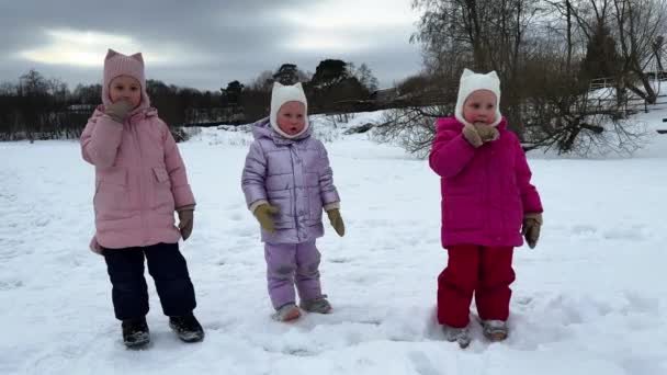Little Sisters Triplets Stand Ice Frozen Lake Wearing Warm Clothes — Stock Video