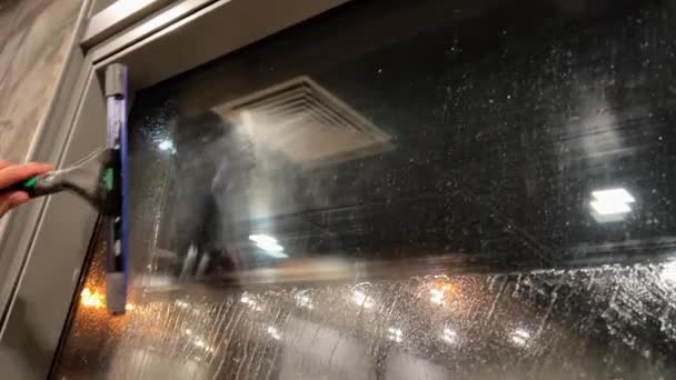 一个清洁工用从外面传来的尖叫声擦洗玻璃杯 你可以看到主人在倒影中 高质量的4K镜头 — 图库视频影像