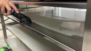 Elektrikli süpürge paslanmaz çelik raftan toz topluyor. Yüksek kalite 4k görüntü