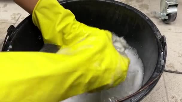 Wassen Een Emmer Vieze Dweil Met Handen Gele Handschoenen Schoonmaakbedrijf — Stockvideo