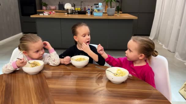 Küçük Üçüz Kız Kardeş Mutfakta Beyaz Tabaklardan Spagetti Yiyorlar Yüksek — Stok video