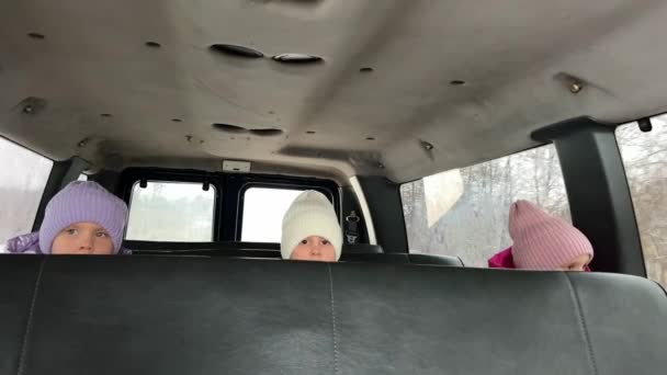 Trzy Siostry Trojaczki Jeżdżą Zimą Tylnym Siedzeniu Dużego Samochodu Kapeluszach — Wideo stockowe