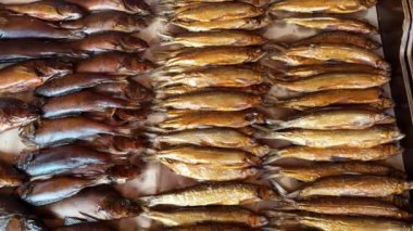 Video, kırsal bir ahşap masada füme balık sunumunu çok güzel sunuyor. Bu inceliğin mutfak cazibesini ve sanatsallığını gösteren, tepsilerde farklı renkte çeşitli tipler gösteriliyor