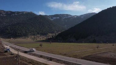 Beyaz bir karavan, uzun bir yolculukta otoban boyunca bir İHA 'yı vuruyor. Yüksek kalite 4k görüntü