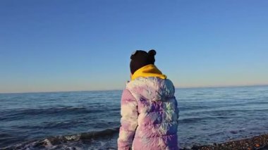 Bir kız kışın deniz dalgasından kaçar. Yüksek kalite 4k görüntü