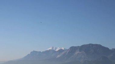 F-16 savaş uçağı, deniz üzerinde, arka plandaki dağlara karşı akrobatik hareketler yapar. Yüksek kalite 4k görüntü