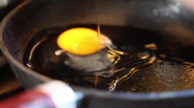Çiğ yumurta sıcak dökme demir tavaya dönüşür. Yüksek kalite 4k görüntü