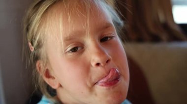 İki küçük kız dudaklarını yalıyor ve doğrudan kameraya bakıyor. Yüksek kalite 4k görüntü