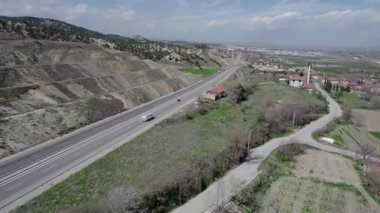 Bir karavanda seyahat eden bir karavan, ilkbaharda bir dron tarafından vurulan tarlalar ve dağlar arasında yol boyunca yolculuk ediyor. Yüksek kalite 4k görüntü