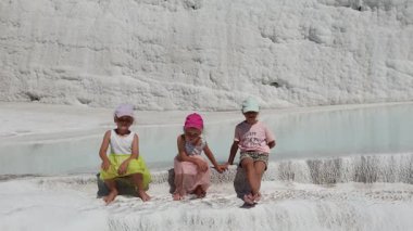Pamukkale, Türkiye 'de küçük çocukları ve üç bacaklı kızları olan bir aile yürüyor. Yüksek kalite 4k görüntü
