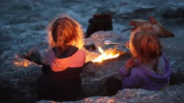 Küçük ikiz kardeşler Türkiye 'deki Chimera Dağı' nın ateşinde marşmelov kızartıyorlar. Yüksek kalite 4k görüntü