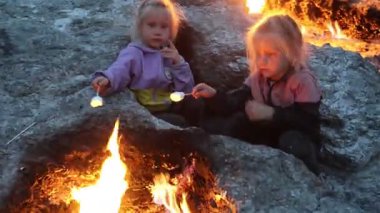 Küçük ikiz kardeşler Türkiye 'deki Chimera Dağı' nın ateşinde marşmelov kızartıyorlar. Yüksek kalite 4k görüntü