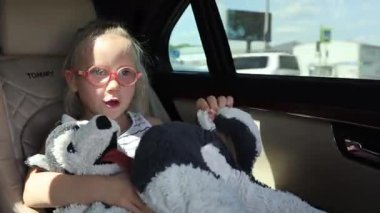 Küçük kızlar arabanın arka koltuğunda oturuyorlar. Yüksek kalite 4k görüntü