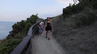 Çocuklu bir aile Kırım 'daki Golitsyn patikasında yürüyor. Yüksek kalite 4k görüntü