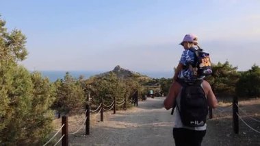 Çocuklu bir aile Kırım 'daki Golitsyn patikasında yürüyor. Yüksek kalite 4k görüntü