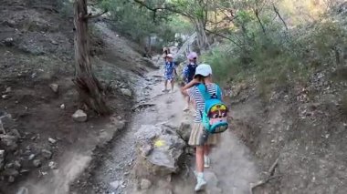 Çocuklu bir aile Kırım 'daki Golitsyn patikasında yürüyor. Yüksek kalite 4k görüntü