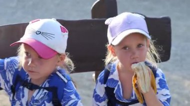 İki ikiz kardeş bankta dans ediyor. Yüksek kalite 4k görüntü