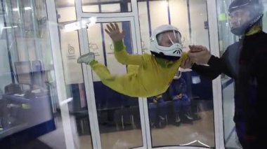 İlk kez küçük bir çocuk bir eğitmenle birlikte bir aerotube içinde uçuyor. Yüksek kaliteli FullHD görüntüler