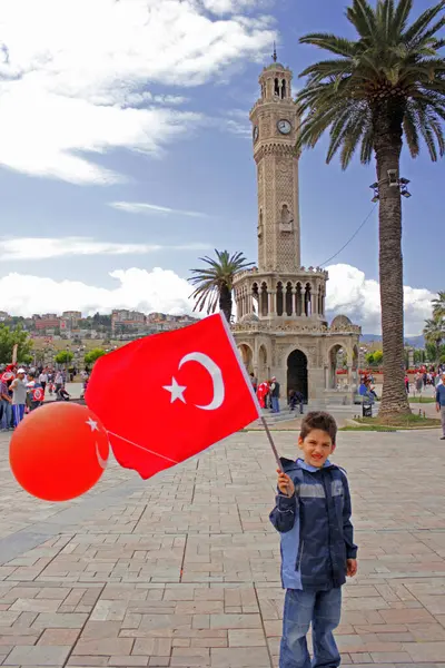 İzmir, Türkiye - 9 Eylül 2012: Çocuk 9 Eylül kutlamalarında Türk bayrağı taşıyor. (İzmir 'in Kurtulusu) Saat kulesi. Mustafa Kemal Atatürk. 23 Nisan, 19 Mayıs, 30 Agustos, 29 Ekim, 9 Eylul.