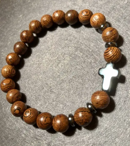 stock image Wooden prayer bracelet with cross made from natural beads and decorative accents displayed on a felt gray fabric