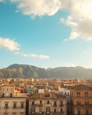 Önünde güzel binalar olan Sicilya tepelerinin manzarası.