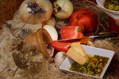 Taze sebzeli çeşitli kırsal mutfak malzemeleri ve seramik kasede lezzetli bir kase çorba..