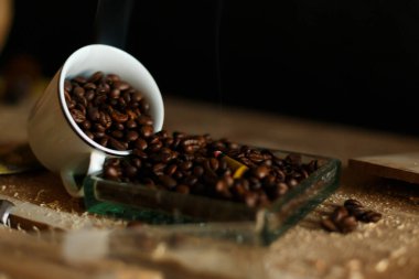 An incredibly charming image of coffee beans delightfully spilled from a rustic cup, exuding warmth and rich aroma clipart