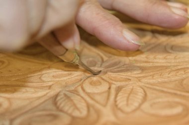 Erkek eli, tahtanın üzerindeki kabartmalı deriyi eski guadametikalar gibi altında mankenlik kiliyle hazırlıyor..