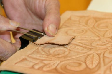 Erkek eli, tahtanın üzerindeki kabartmalı deriyi eski guadametikalar gibi altında mankenlik kiliyle hazırlıyor..