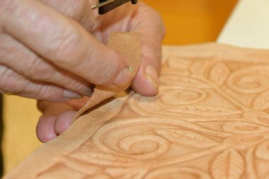 Erkek eli, tahtanın üzerindeki kabartmalı deriyi eski guadametikalar gibi altında mankenlik kiliyle hazırlıyor..