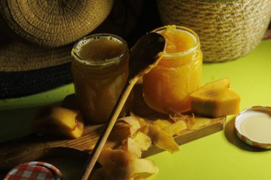 Kavanozlarda sergilenen canlı ve parlak mango reçeli yumuşak doğal ışıkla kırsal elementleri vurguluyor.