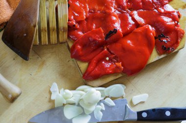 Doğranmış sarımsak ve kavrulmuş kırmızı biber artık hazır ve kesme tahtasının üzerinde dinlenmeye hazır.