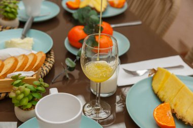 Renkli meyveler, lezzetli pastalar ve sergilenen ferahlatıcı içeceklerle süslü bir brunch masası.