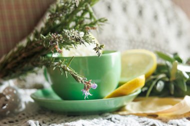 Sakinleştirici bir ortamda bitkisel çay, taze limon ve canlı yeşillik içeren güzel sakin bir kompozisyon.