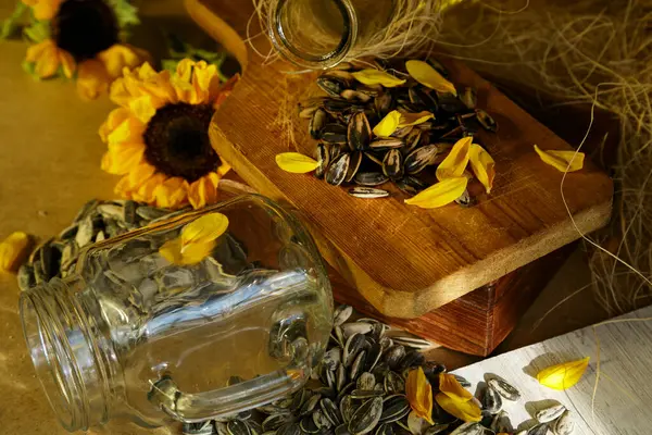 Kırsal bir ahşap yüzeyde canlı bir ayçiçeği tohumu ve taç yaprakları görüntüsü, güzelliğin vücut bulmuş hali..