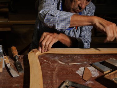 Bir zanaatkar karmaşık ahşap detaylar hazırlıyor, olağanüstü işçilik ve adanmışlık sergiliyor.