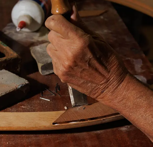 Bir zanaatkar ustalıkla deri oyar, zengin geleneksel zanaatkarlığı ve karmaşık sanatları ön plana çıkarır.
