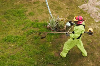 Çok yetenekli bir peyzaj ustası parlak kıyafetler giyip titizlikle çeşitli aletleri kullanarak güzel bir bahçeyi besliyor.