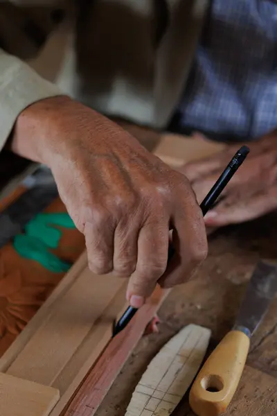 Yetenekli bir zanaatkar dikkatli ölçüm ve aletlerle ahşap işçiliğinin hassasiyetini ve karmaşıklığını sergiler.