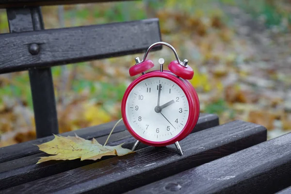 秋天公园的闹钟在长椅上 时间的流逝与季节的变化 — 图库照片