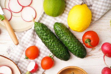 Tahta arka planda turp ve diğer bahar sebzeleriyle dolu bir kase..