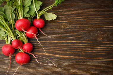 Ahşap zemin üzerinde taze kırmızı turp ve metin için yer var. Düz yatıyordu.